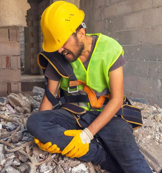 Image of a construction site worker after having a job-site incident causing pain in his knee